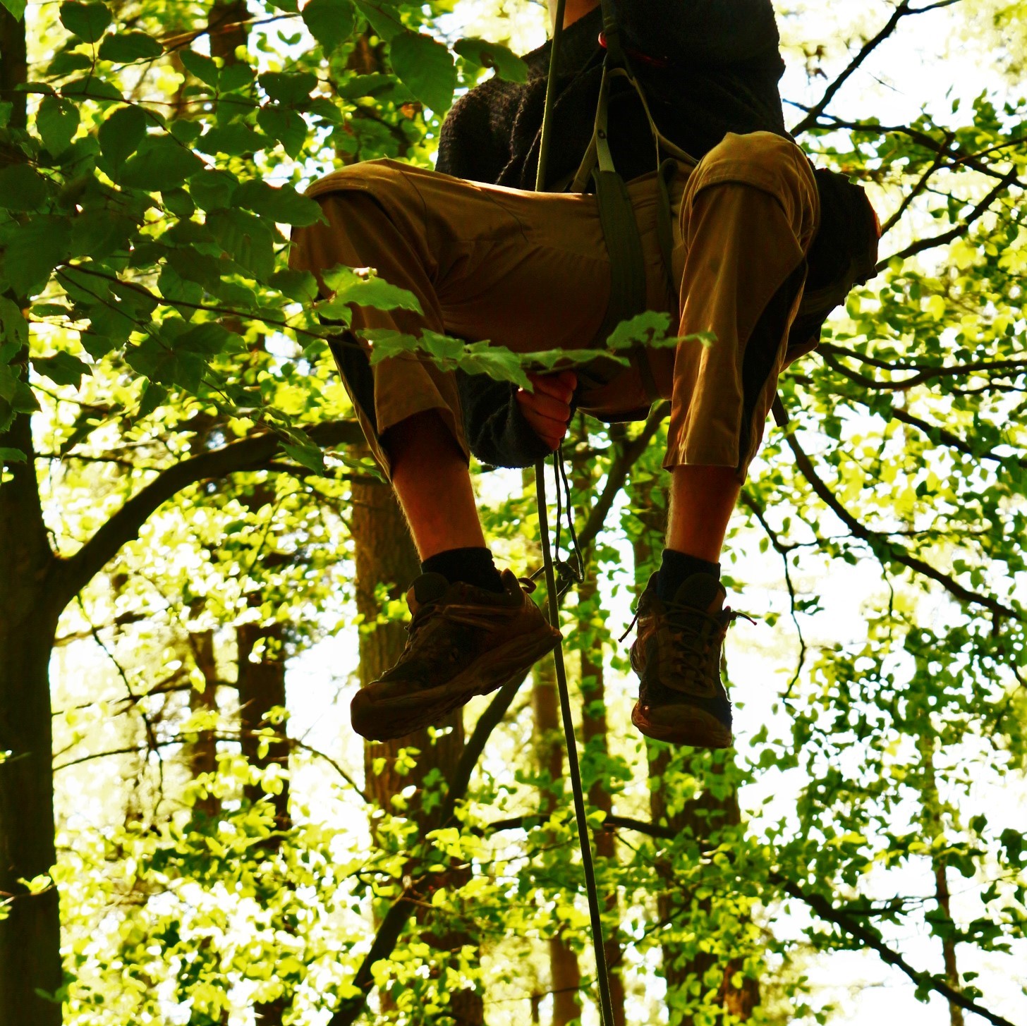 Ein Mensch klettert ein Seil runter